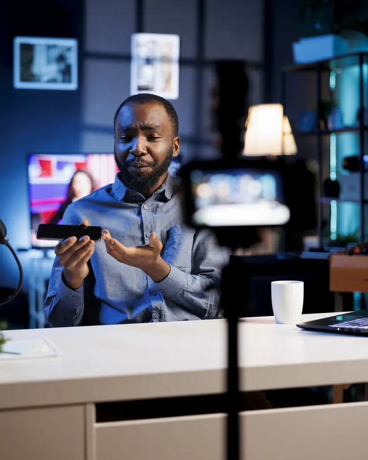 A tech reviewer filming a phone review in his studio