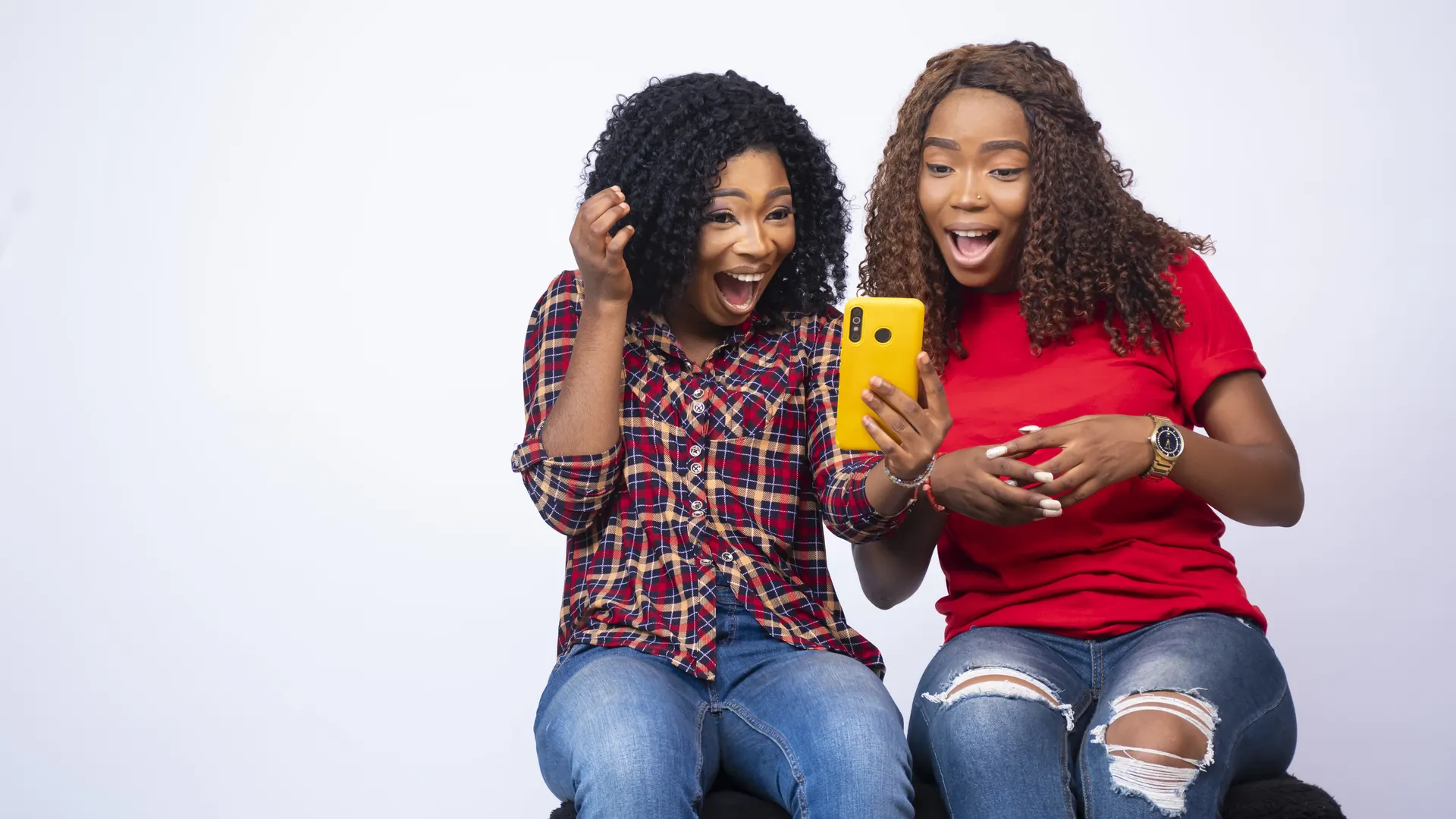 Two friends reacting with excitement to a post on a phone